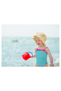 sun safety baby at the beach in a sun hat with sand bucket