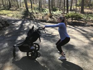 woman squatting with a jogging stroller