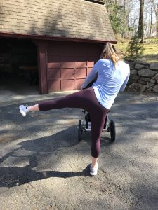woman with jogging stroller doing a side lunge