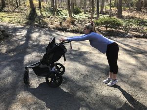 woman stetching with her jogging stroller
