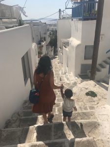 Mom and toddler walking down steps in Mykonos, Greece.
