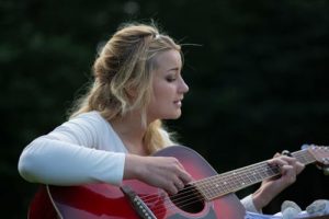 woman playing a guitar at a children's birthday party