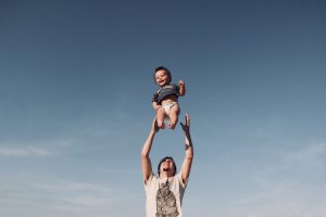 photo of man raising baby in the air--Father's Day gift ideas